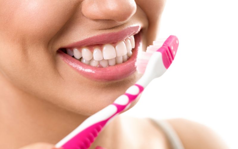 Frau putzt Zähne, um Paradontose vorzubeugen